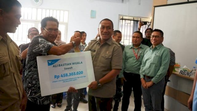 Bupati Luwu Timur, Irwan Bachri Syam, menyerahkan kompensasi secara simbolis di Aula Kantor Camat Towuti.