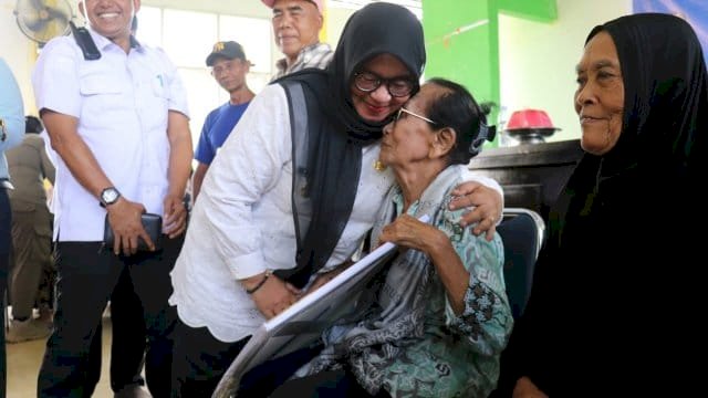 Wakil Bupati Luwu Timur, Hj. Puspawati Husler, menyerahkan bantuan Program Kartu Lutim Lansia berupa uang tunai dan buku rekening Bank Sulselbar.